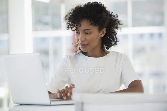 Fokussierte Frau arbeitet im Büro am Laptop — Stockfoto