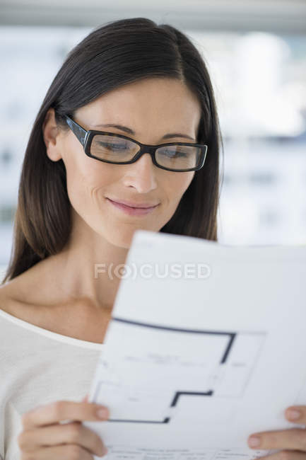 Close-up of woman in eyeglasses reading document — Stock Photo