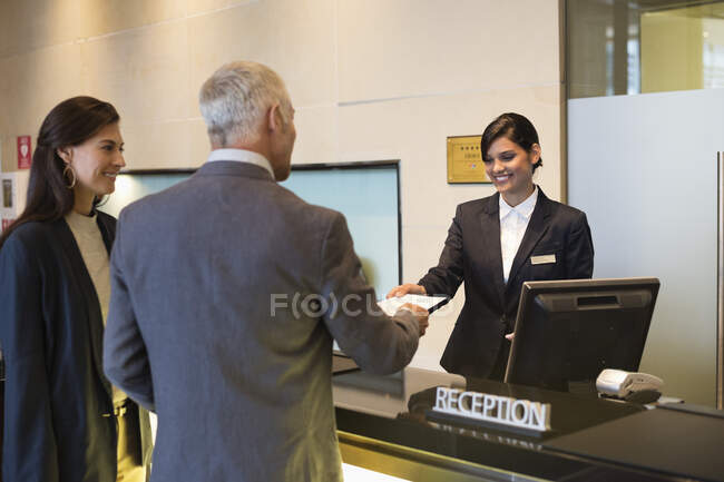 Casal de negócios check-in hotel — Fotografia de Stock