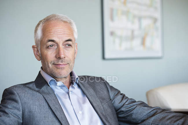 Close-up of confident mature businessman sitting and thinking — Stock Photo