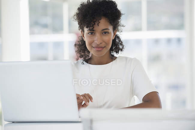 Портрет жінки, що сидить перед ноутбуком в офісі — стокове фото