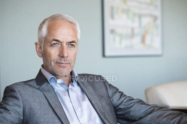 Close-up de homem de negócios maduro confiante sentado e pensando — Fotografia de Stock