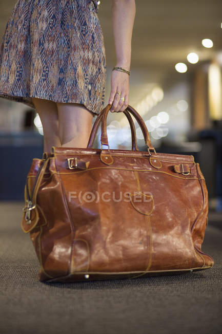 Close-up of female hand picking up travel leather purse — Stock Photo