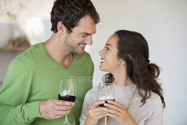 Pareja sosteniendo copas de vino y sonriendo - foto de stock