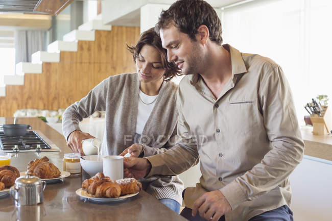 Coppia che fa colazione al bancone della cucina — Foto stock