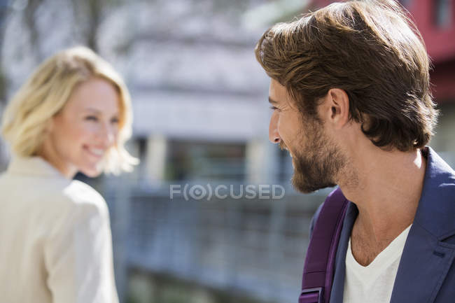Sorrindo homem e mulher olhando um para o outro na rua — Fotografia de Stock