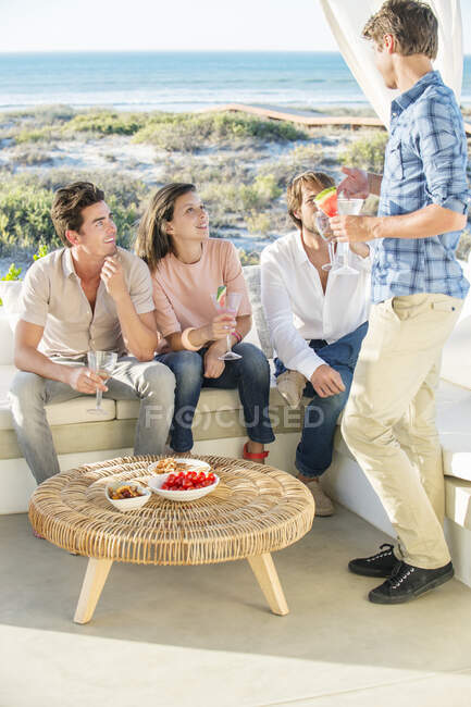 Group of friends enjoying drinks outdoors on vacation — Stock Photo