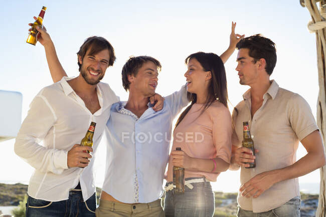 Four friends drinking beer — Stock Photo