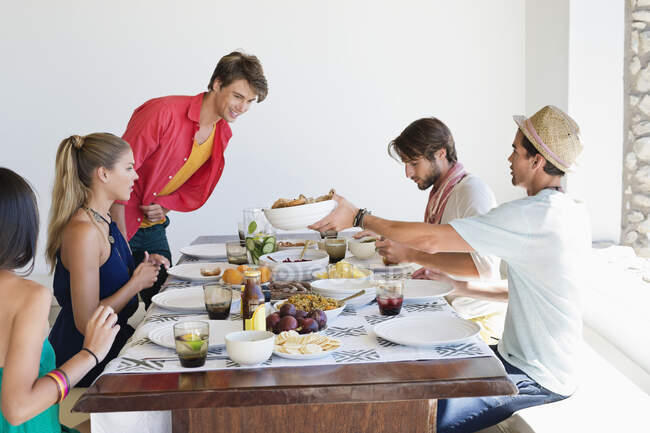Amigos almoçando na mesa de jantar — Fotografia de Stock