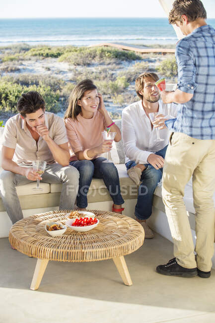 Grupo de amigos disfrutando de bebidas al aire libre de vacaciones - foto de stock