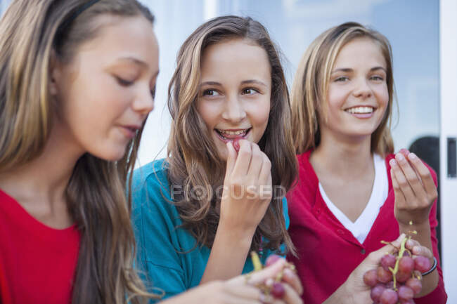 Close-up of three girls eating grapes — Stock Photo