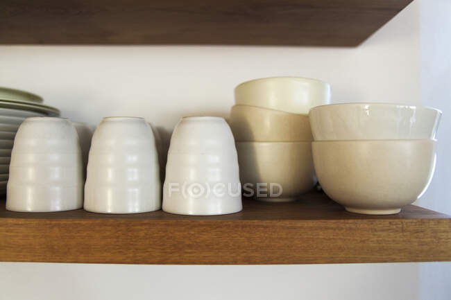Bowls and glasses on a shelf — Stock Photo