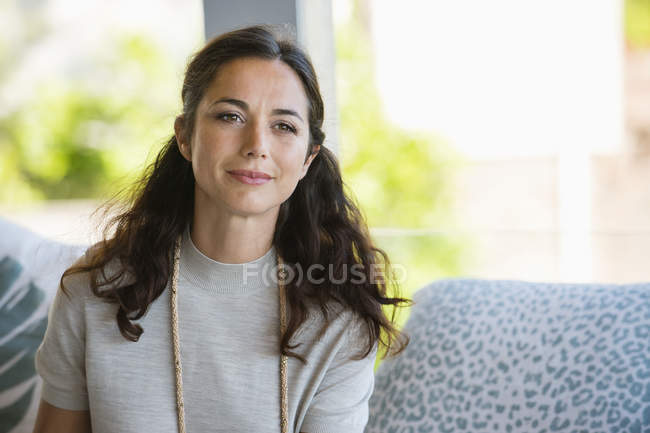 Porträt einer lächelnden Frau, die zu Hause wegschaut — Stockfoto