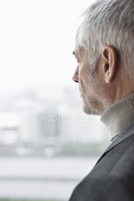 Confiante homem maduro pensativo olhando através da janela — Fotografia de Stock