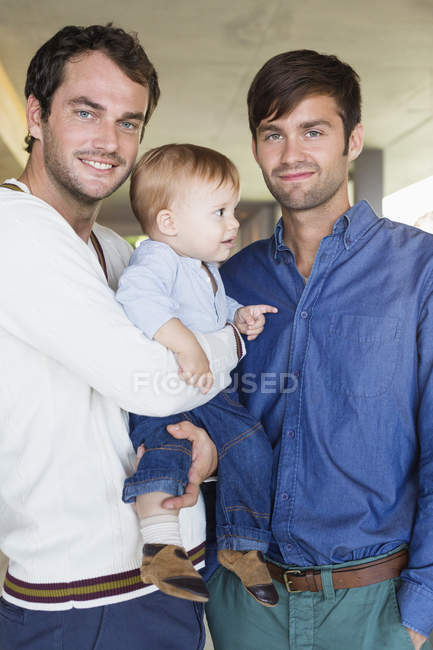 Портрет щасливих батьків lgbt посміхаються з сином вдома — стокове фото