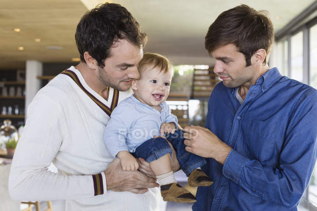Retrato de feliz lgbt pais sorrindo com filho em casa — Fotografia de Stock