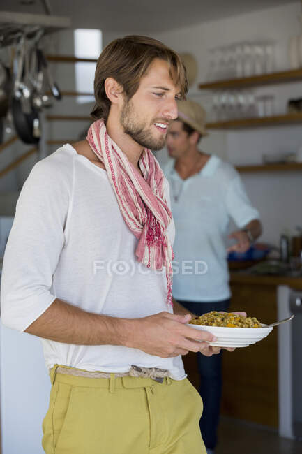 Uomo che porta un piatto di cibo — Foto stock