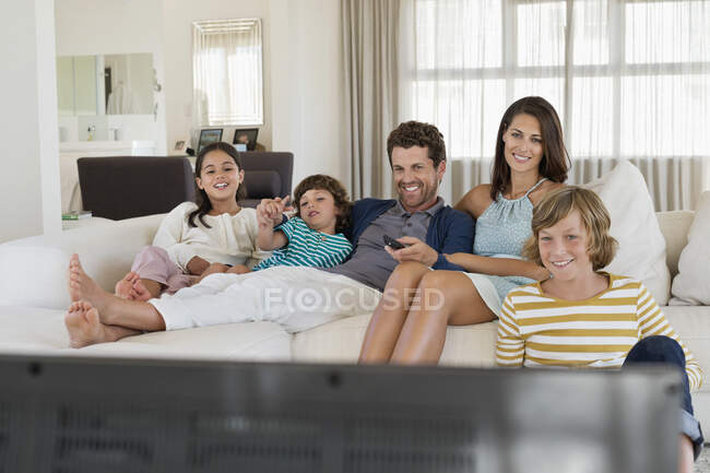 Famille regardant la télévision à la maison — Photo de stock