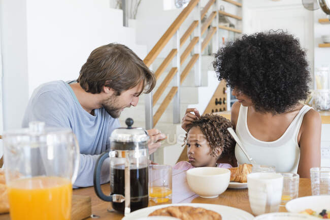 Parents avec leur fille à une table à manger — Photo de stock