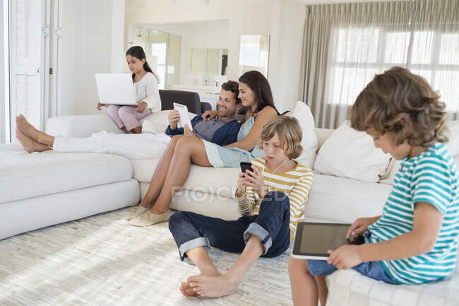 Famille utilisant gadget électronique — Photo de stock