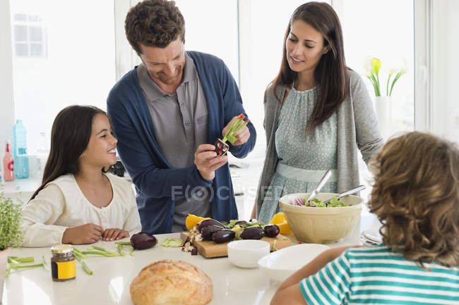 Щаслива сім'я готує їжу на кухні — стокове фото