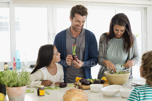 Familia feliz preparando comida en la cocina - foto de stock
