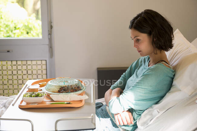 Anorexia nervosa patient with a food tray in hospital ward — Stock Photo