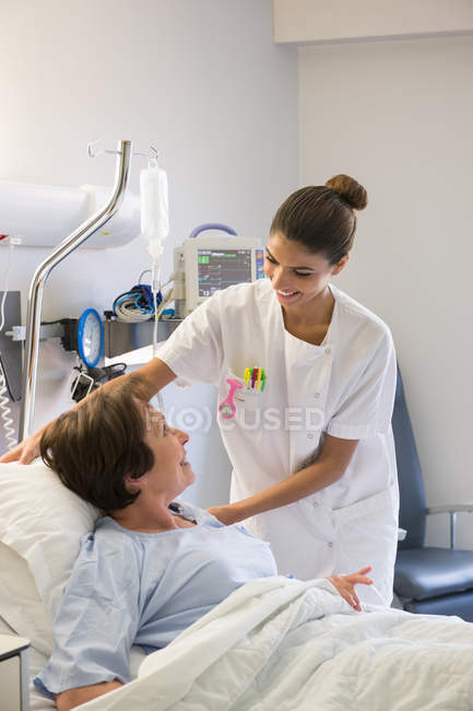 Krankenschwester hilft Patientin auf Krankenhausbett — Stockfoto