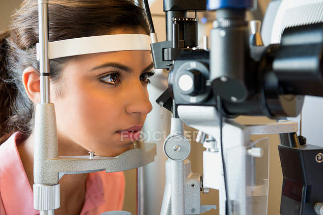 Paciente femenina sometida a examen ocular en clínica - foto de stock
