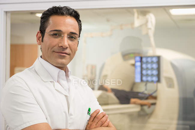 Retrato del médico varón sonriente de pie en la sala de resonancia magnética médica - foto de stock