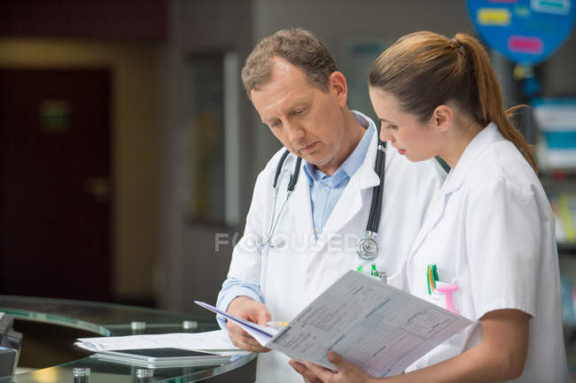 Two doctors discussing medical report in hospital — Stock Photo