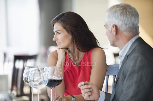 Pareja disfrutando de vino tinto en restaurante - foto de stock