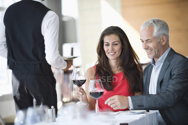 Couple enjoying red wine in restaurant — Stock Photo