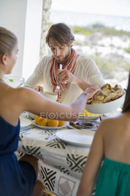 Friends sitting at a dining table having lunch — Stock Photo