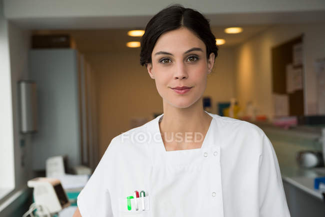 Portrait of smiling female nurse standing in hospital — Stock Photo