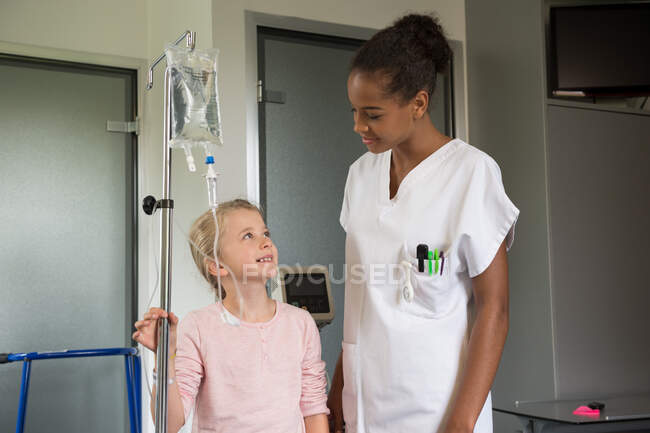 Enfermera asistiendo a una paciente en el hospital - foto de stock