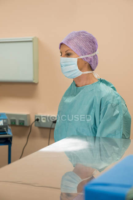Chirurgo donna in piedi in sala operatoria — Foto stock