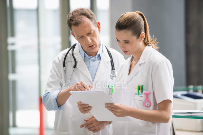 Due medici che discutono di rapporto medico in ospedale — Foto stock