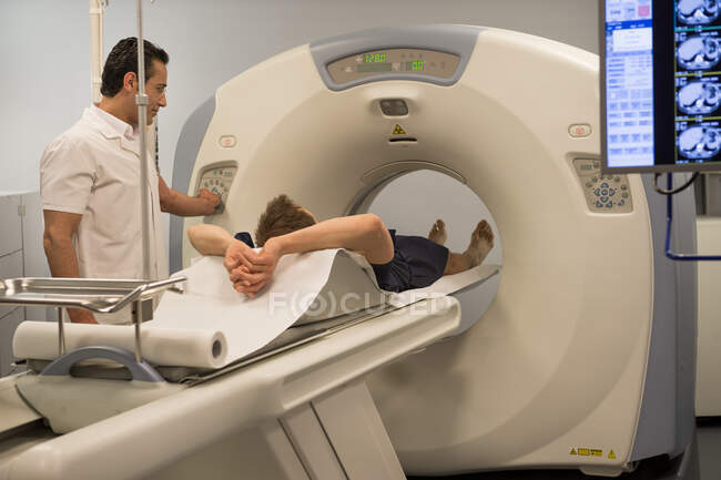 Médico varón preparando al paciente para una resonancia magnética en el hospital - foto de stock