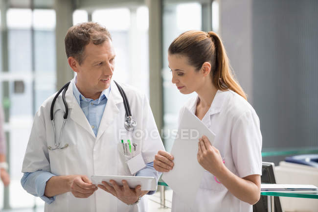 Deux médecins analysant un rapport médical sur une tablette numérique à l'hôpital — Photo de stock