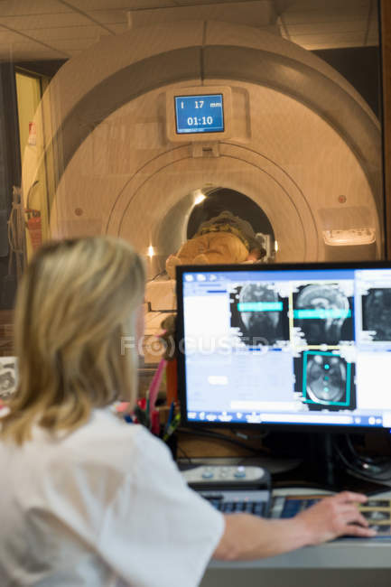 Portrait d'une femme médecin examinant une IRM cérébrale sur ordinateur — Photo de stock