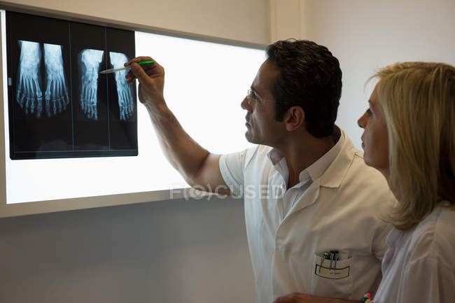 Médicos examinando informe de rayos X en el hospital - foto de stock