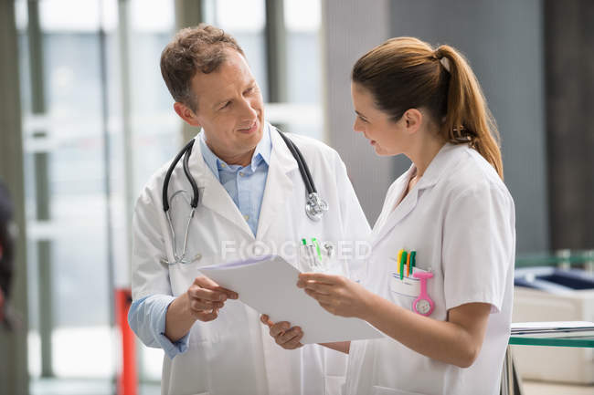 Two doctors analyzing medical report on digital tablet in hospital — Stock Photo