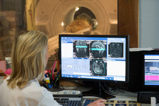 Ritratto di medico donna che esamina la risonanza magnetica cerebrale sul computer — Foto stock