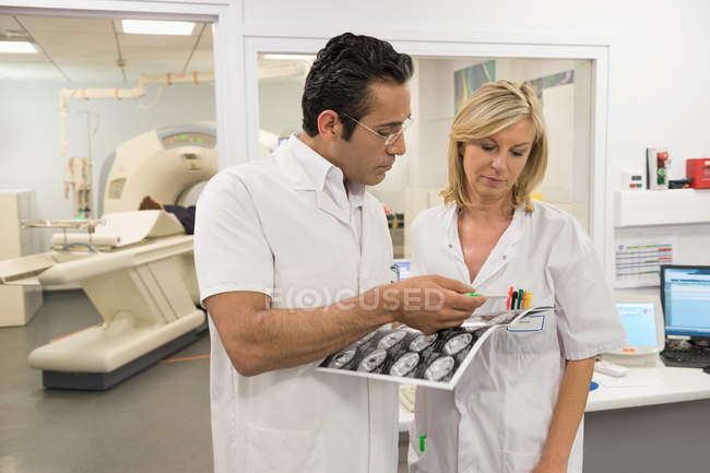 Лікарі розглядають звіт про перевірку МРТ в медичному залі — стокове фото
