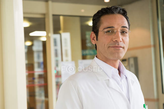 Retrato del médico masculino sonriendo en el hospital - foto de stock