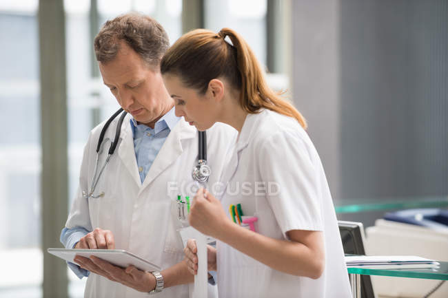 Two doctors discussing medical report in hospital — Stock Photo