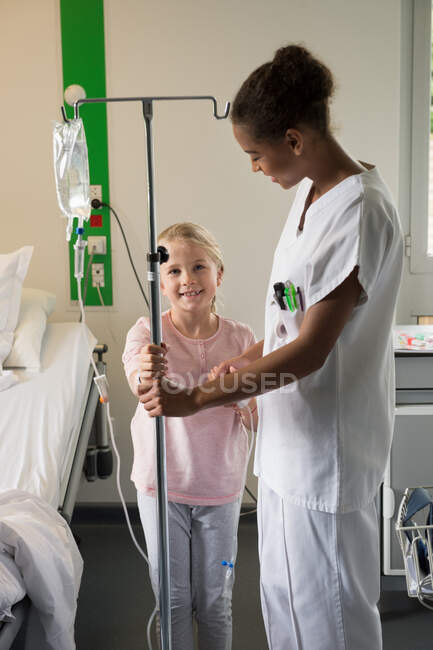 Infermiera femminile che assiste una ragazza paziente in ospedale — Foto stock