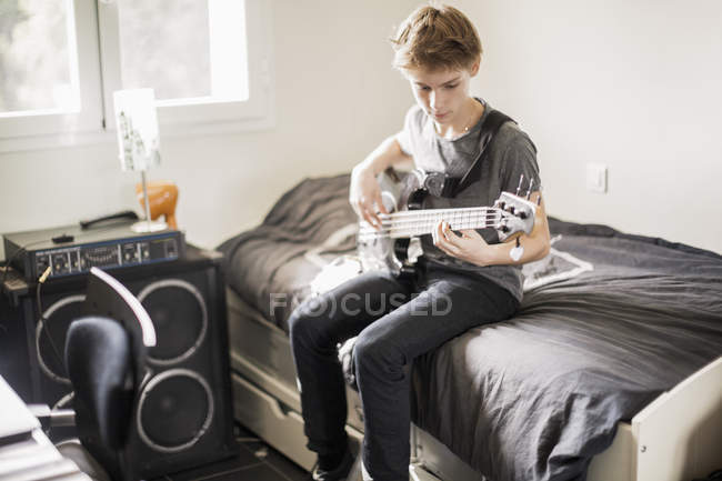 Adolescent garçon jouer guitare à la maison — Photo de stock