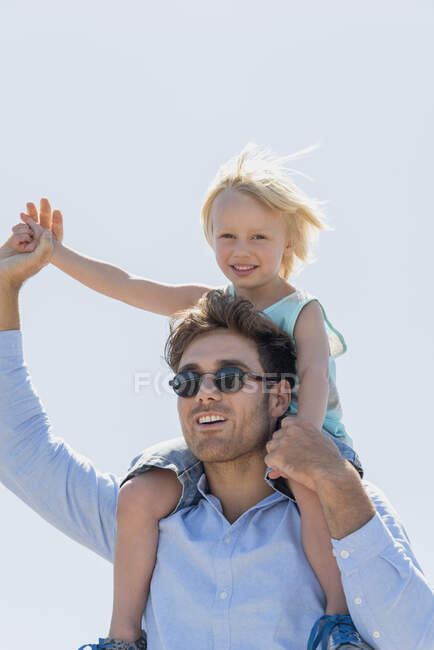 Young man carrying his son on his shoulders — Stock Photo